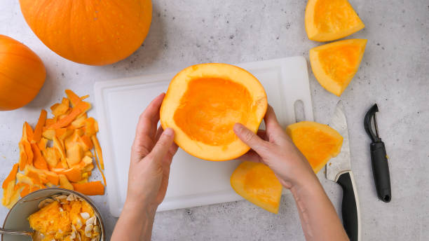 istock Peeled raw pumpkin slices close up on cutting board, flat lay, grey stone background 1409384292