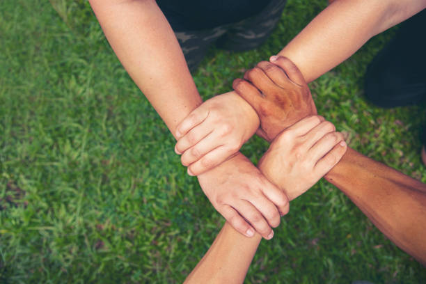 istock Top View Four hands Diverse multiethnic Partner team together. Close up Teamwork group of Four multiracial people join hands together. Above view Diversity people hand join partner team trust team 1409392737