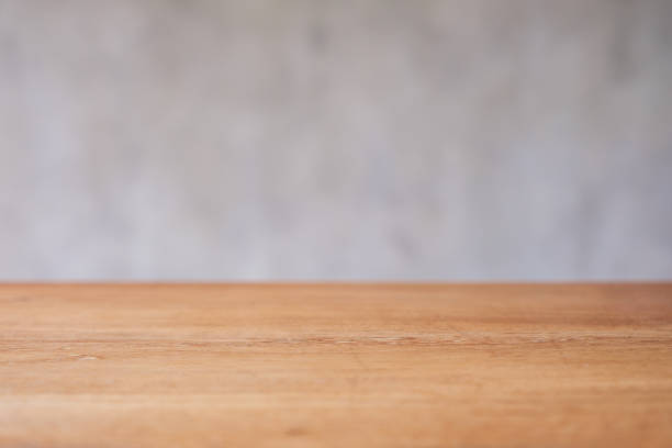 istock Wooden table top with blurred of concrete wall background 1409392987
