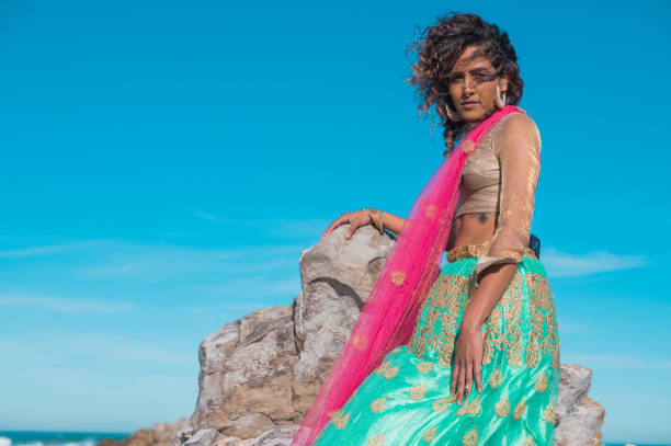 istock Confident woman seen sitting on a rock 1409398088
