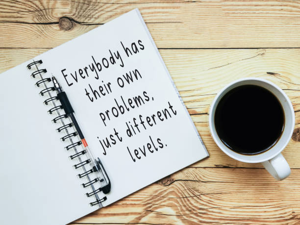 istock Open notebook with text Everybody has their own problems, just different levels and a cup  of coffee on wooden background. 1409402154