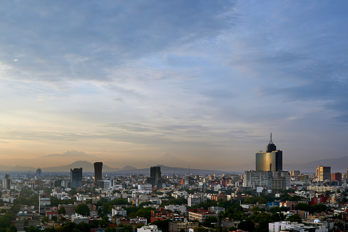 panoramic photo of a beautiful sunrise in mexico city with volcanos in the background (Iztaccíhuatl,  popocatepetl)