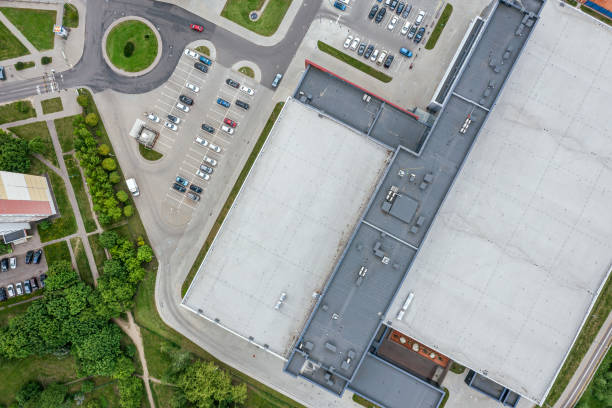 capannone industriale con parcheggio in zona residenziale. vista aerea dall'alto dal drone volante. - industrial district foto e immagini stock