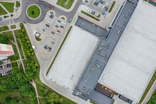 industrial building with parking lot in residential area. aerial top view from flying drone.
