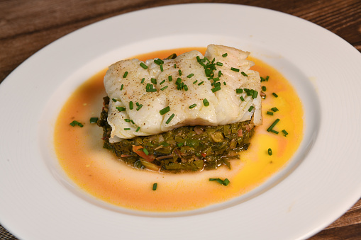 Recipe for chard, tomato, onion and lemon fondue with cod fillet and chives. High quality photo