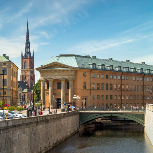 sveriges riksdag, zentralbehörde von schweden mit turm der klara-kirche am anderen ende, altstadt, oder gamla stan, stockholm, schweden - sveriges helgeandsholmen stock-fotos und bilder