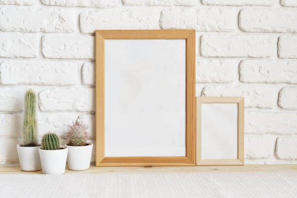 istock Square wooden photo frame and cactus plants on the table 1409413317