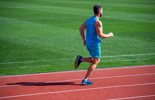 A male athlete is gearing ready for relay race.