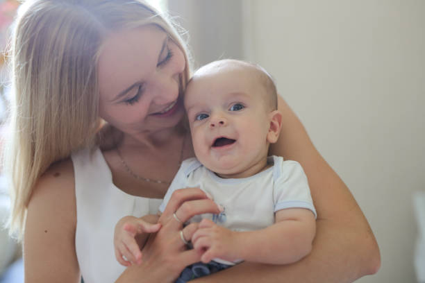 istock blonde mom kiss and hug baby, real interior 1409416507