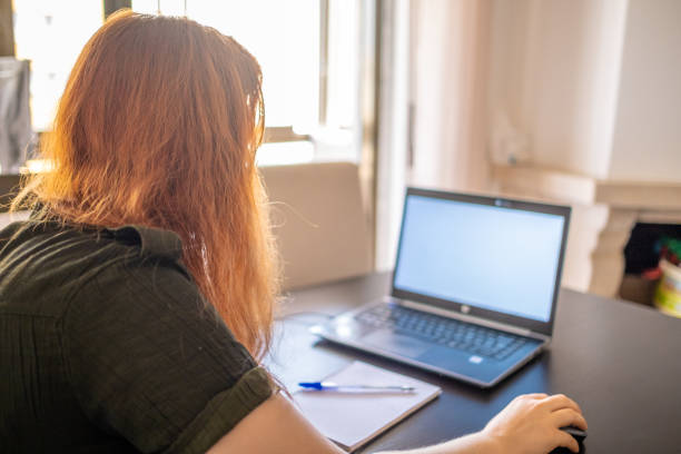 istock Woman taking online courses with laptop and notebook and pen 1409417916