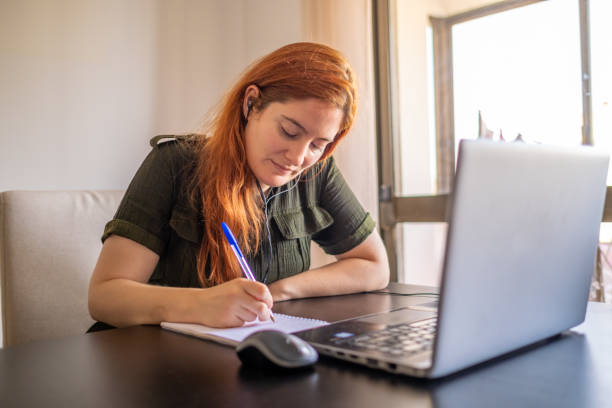 istock Woman taking online courses with laptop and notebook and pen 1409417973