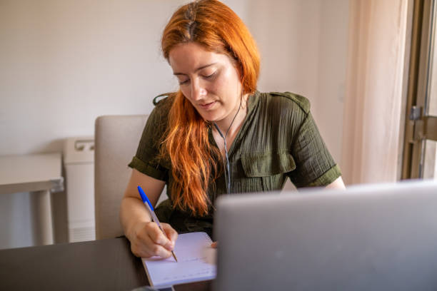 istock Woman taking online courses with laptop and notebook and pen 1409418517