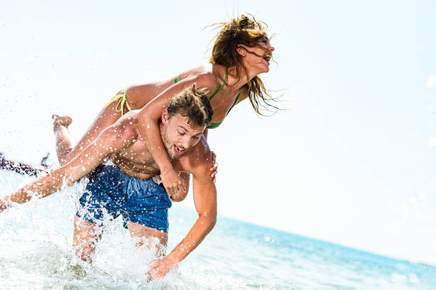 istock Carefree couple having fun while piggybacking in sea. 1409418882