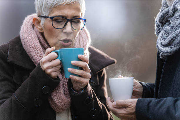 istock Senior woman drinking hot drink in nature. 1409421013