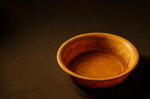 Empty bowl on dark background with copy space, hunger concept