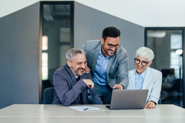 istock Smiling team work looking something online, over the laptop. 1409422571