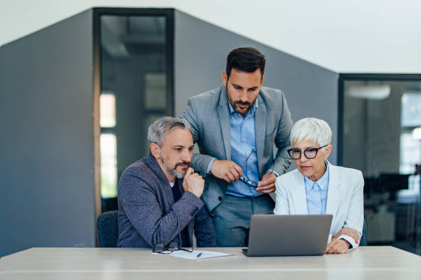istock Concentrated people working with their boss, looking at the laptop. 1409422574