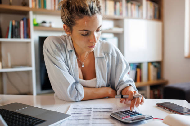 istock Young woman analyzing bills at home 1409423392
