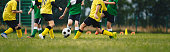 istock Kids play football on outdoor field. Children score a goal during a soccer game. Boys kicking ball. Running children in team jersey and cleats. School football club. Sports training for a young player 1409423595