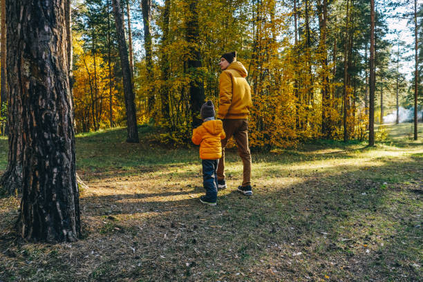 istock Father and son walking in autumn forest. 1409423857
