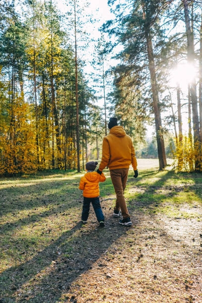istock Father and son walking in autumn forest. 1409423861