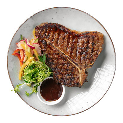 Isolated portion of grilled beef t-bone steak on white background