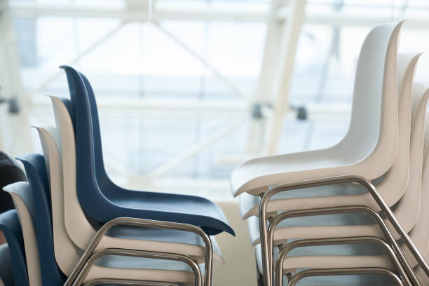 istock White and blue plastic chairs in a row are waiting for visitors. White plastic chairs stand on top of each other against the background of the window. 1409424202