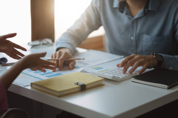 istock Two business people talking about graph and analysis about finance budget company and using calculator in office room 1409424314