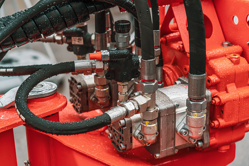 Hydraulic power unit mechanical valve with pipes and connections on heavy industry machine close-up