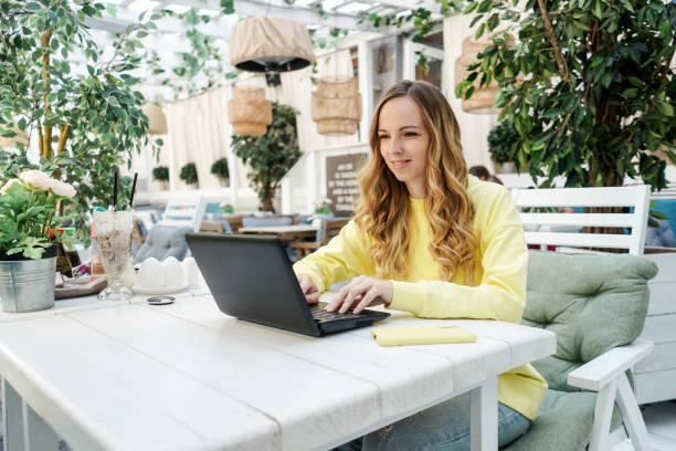 istock Young female freelancer work in summer cafe. 1409425417
