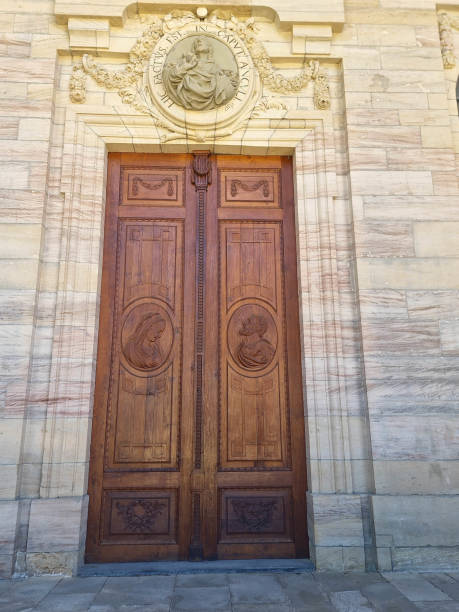 Large wooden door with ornaments framed with sandstone. Entrance gate to the cathedral in Sankt Blasien. Black Forest, Germany. July 07, 2022