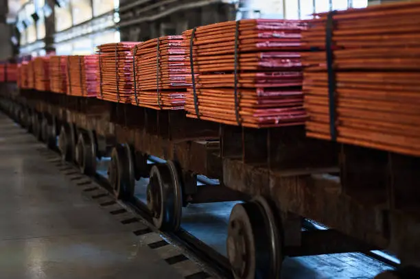 Photo of Cathode copper sheets on rail carriages in warehouse