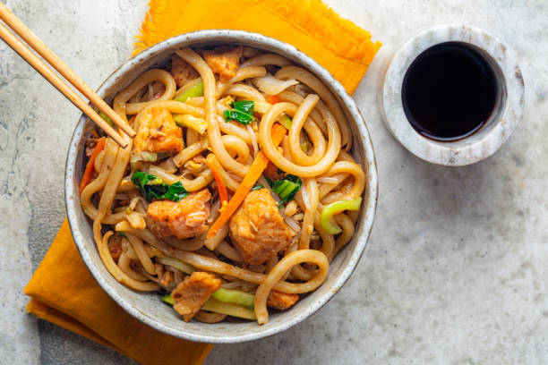Stir Fried Yaki Udon Noodles with Salmon Fish, Vegetables and Soy-based Sauce. Directly above. stock photo
