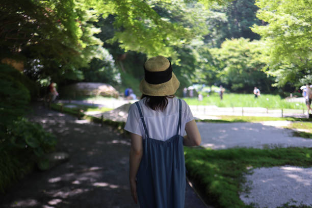 緑の夏の庭を歩く若い女性