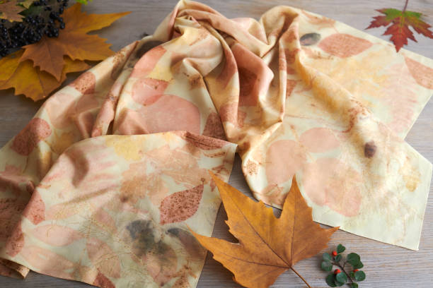 istock Hand-dyed silk scarf surrounded by berries and autumn leaves. Eco-print technique 1409428549