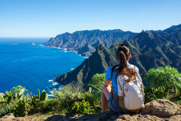 woman hiker watching beautiful costal scenery. - tenerife, canary islands, spain. coast view, mountain anaga - tenerife stockfoto's en -beelden
