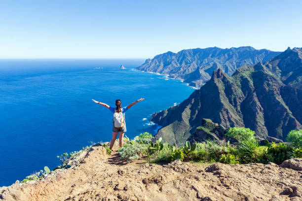 woman hiker watching beautiful costal scenery. - tenerife, canary islands, spain. coast view, mountain anaga - tenerife stockfoto's en -beelden