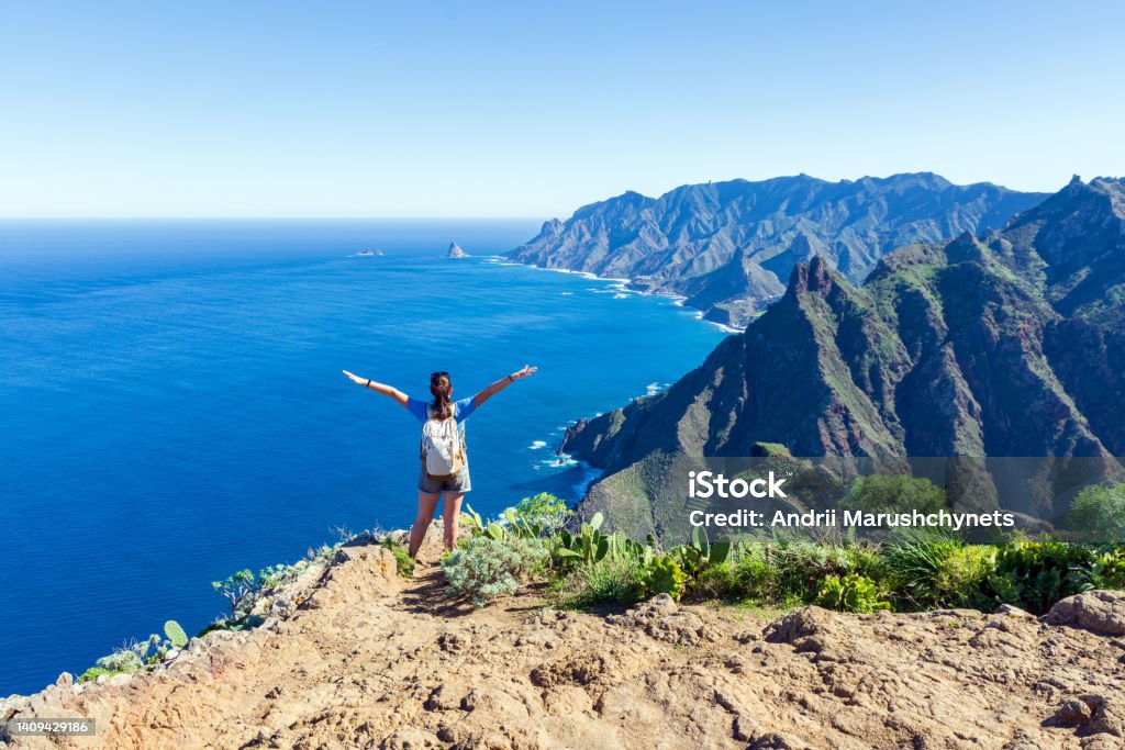 Woman hiker watching beautiful costal scenery. - Tenerife, Canary Islands, Spain. coast view, mountain Anaga Tenerife Stock Photo