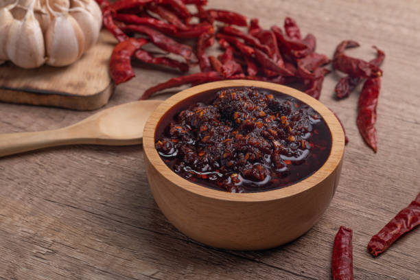 istock Thai spicy chili paste in a wooden cup (nampnikpao) 1409430467