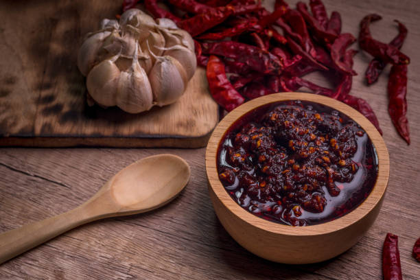 istock Thai spicy chili paste in a wooden cup (nampnikpao) 1409430645