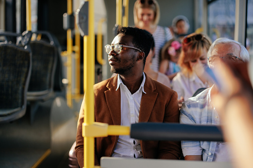 Young black man riding on a city public bus
