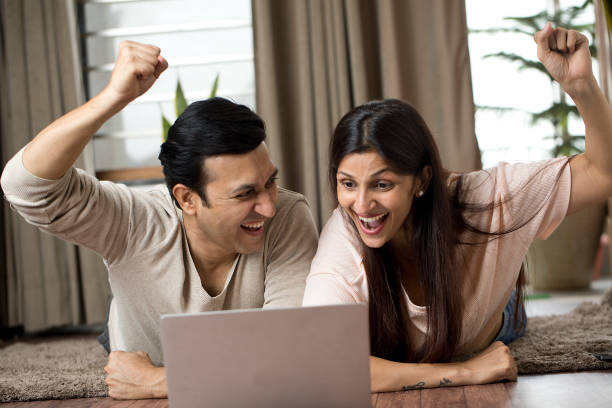 istock Ecstatic couple celebrating online success at home 1409432805