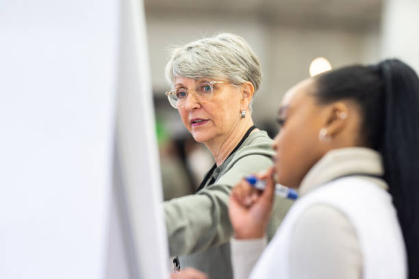 diverse business women discussing on a flipchart in workshop - business seminar writing women imagens e fotografias de stock