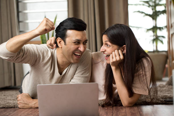 istock Ecstatic couple celebrating online success at home 1409432940
