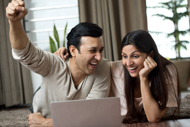 istock Ecstatic couple celebrating online success at home 1409432943