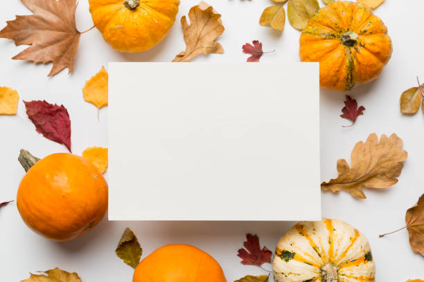 istock Autumn composition with paper blank and dried leaves with pumpkin on table. Flat lay, top view, copy space 1409433555