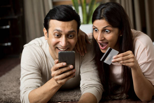 istock Couple using mobile phone for online shopping at home 1409433805