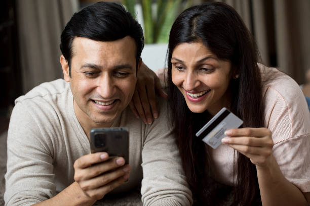 istock Couple using mobile phone for online shopping at home 1409433875
