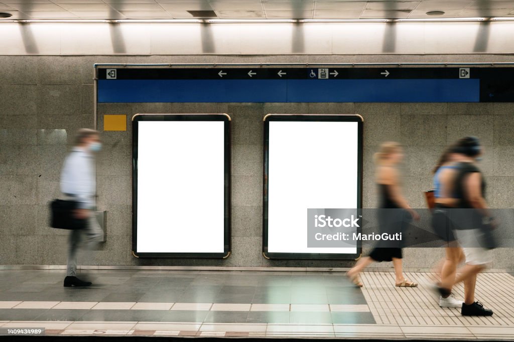 Two blank billboard in a subway station Two blank billboards in a subway station with commuters in blurred motion Billboard Stock Photo