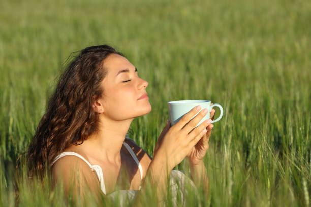 istock Woman relaxing smelling coffee in a wheat field 1409435064